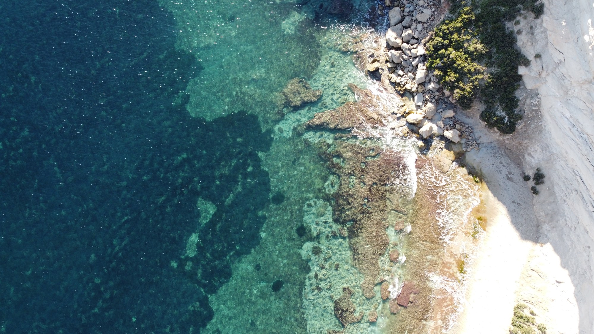 A secluded cove beneath pale limestone cliffs