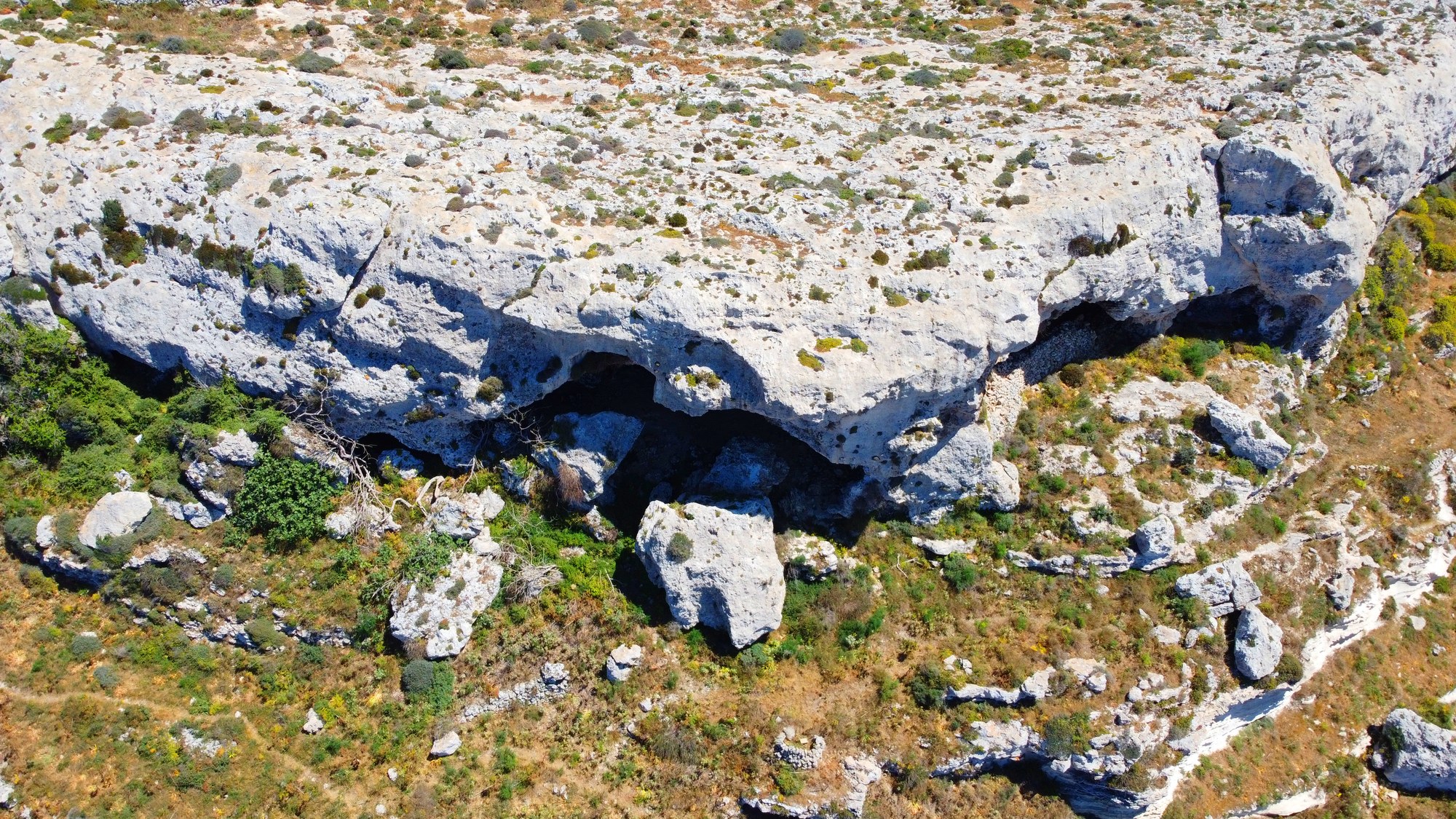 A closer aerial view of the weathered cave openings at San Lawrenz